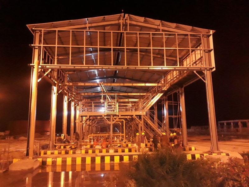 Steel structure industrial facility under construction illuminated at night